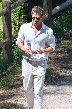 a man in white shirt and tan pants walking