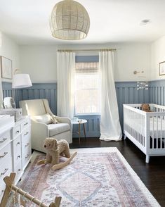 a baby's room with a crib, rocking chair and rug in it