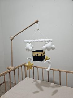 a baby crib with a black bag hanging from it's side and stars on the bottom