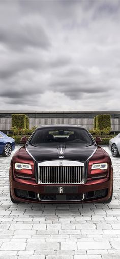 three rolls royces parked in front of each other on a cobblestone driveway