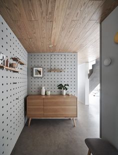 a room with a wooden cabinet and polka dot wallpaper