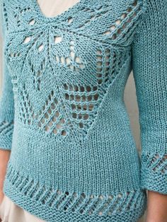 a woman wearing a blue sweater with crocheted details