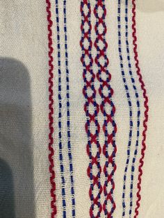 an embroidered cloth with red, white and blue lines