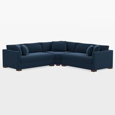 a blue sectional couch with pillows on the back and armrests, in front of a white background