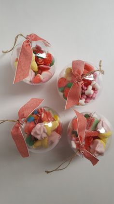 three glass balls filled with candies and ribbons