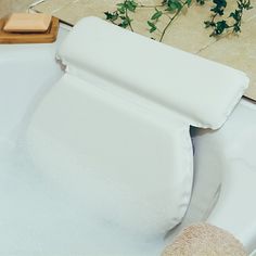 a bathtub filled with white foam next to a plant