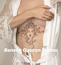 a woman with tattoos on her stomach is wearing a white robe and has an intricate tattoo