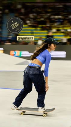 a woman riding a skateboard on top of a track