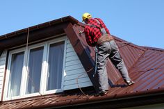 a man working on the roof of a house