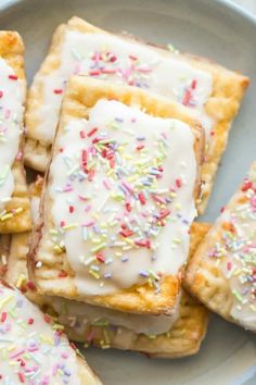 a white plate topped with pastries covered in frosting and sprinkles