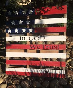 a wooden sign that says in god we trust with an american flag painted on it