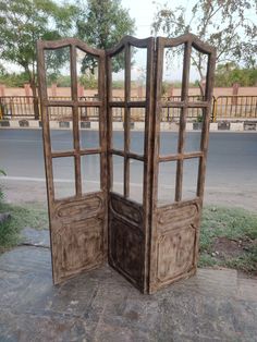 an open wooden door sitting on the side of a road