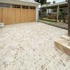 a house with a brick driveway and wooden garage doors