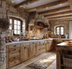 a rustic style kitchen with stone walls and wooden cabinets is pictured in this image, along with an area rug on the floor