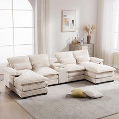 a living room with a large sectional couch and pillows on the floor in front of it