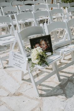 a white chair with flowers and a photo on it sitting in front of a row of chairs