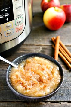 an apple pie in a bowl with cinnamon sticks next to it and an instant pot appliance