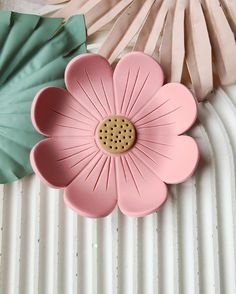 a pink flower sitting on top of a white table