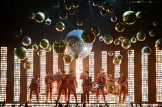 the backs performing on stage with disco balls