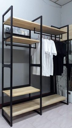 an open closet with clothes hanging on racks