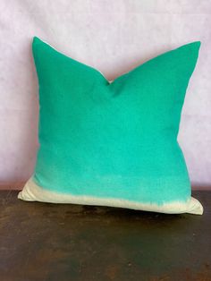 a green pillow sitting on top of a wooden table