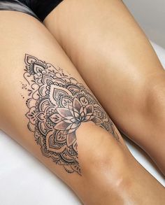 a woman's leg with a tattoo on it, sitting on a white bed