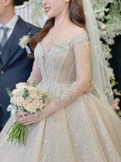 a woman in a wedding dress standing next to a man