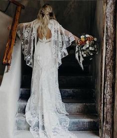 a woman in a wedding dress is walking down the stairs