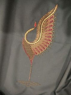 a close up of a piece of cloth with an embroidered bird on it