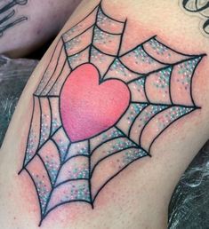 a spider web with a heart tattoo on it's thigh and the word love is in the center