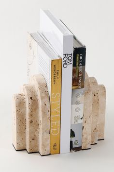 a stack of books sitting next to each other on top of a book shelf in front of a white background