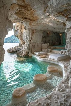 an indoor swimming pool in the middle of a cave with rocks and pebbles around it