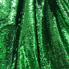 green sequins are covering the surface of a piece of clothing that is being displayed