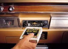 a person is reading a book in front of an old car with the words'a 8 track player '