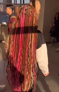 the back of a woman's head with long, multicolored braids