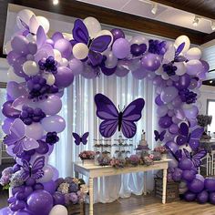 purple and white balloon arch with butterfly decorations