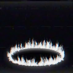 a black and white photo with flames coming out of the center, in front of a dark background