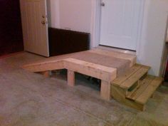 a set of stairs made out of wooden pallets in a room with white doors