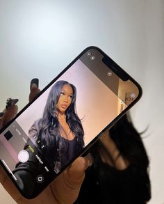 a person holding up a cell phone with an image of a woman on it