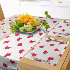 the table is set with placemats and silverware, which are decorated with red hearts