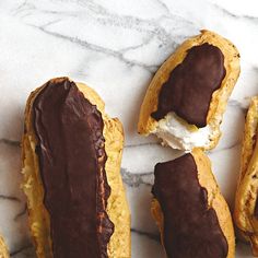 chocolate covered pastries sitting on top of a white marble counter next to each other