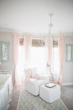 a baby's room with pink curtains and white furniture