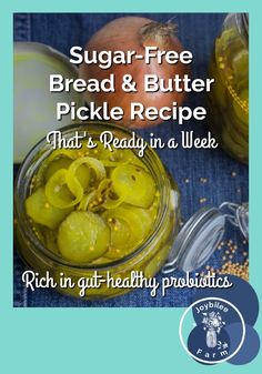 a jar filled with pickles sitting on top of a table next to onions and garlic