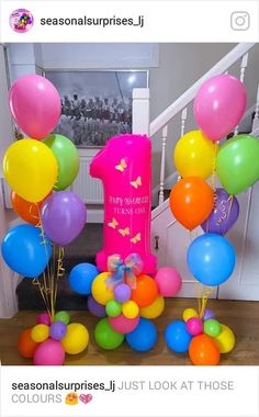 balloons and streamers are on the floor in front of a stair case with a sign that says, happy birthday