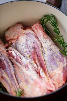 raw meat in a pot with rosemary sprigs