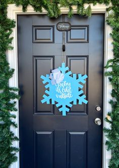 a black door with a blue snowflake on it and the words merry christmas written in white