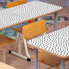 two school desks with polka dot patterned tops and one without the seat covers on them