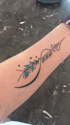 a woman's arm with an arrow and stars tattoo on the left side of her arm