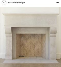 an empty fireplace in a room with white walls