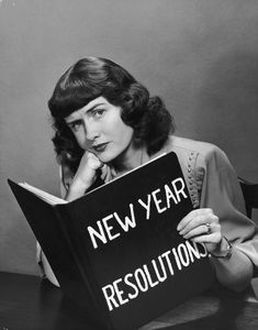 a woman sitting at a table reading a book with the words new year resolution written on it